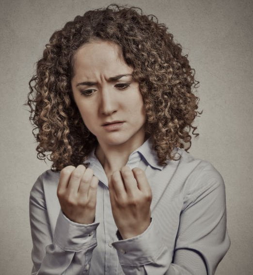 woman performing compulsive behavior by emotionally staring at nails