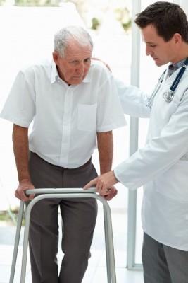 Doctor helps old man to walk
