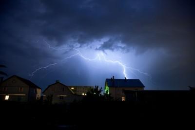 Lighting strikes the houses at night